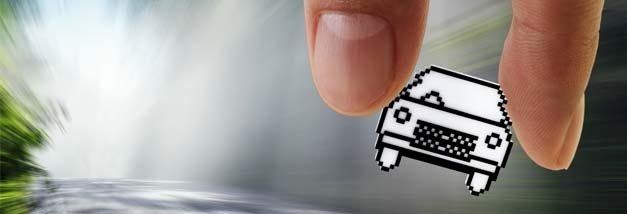 A person is holding a drawing of a car between their fingers.